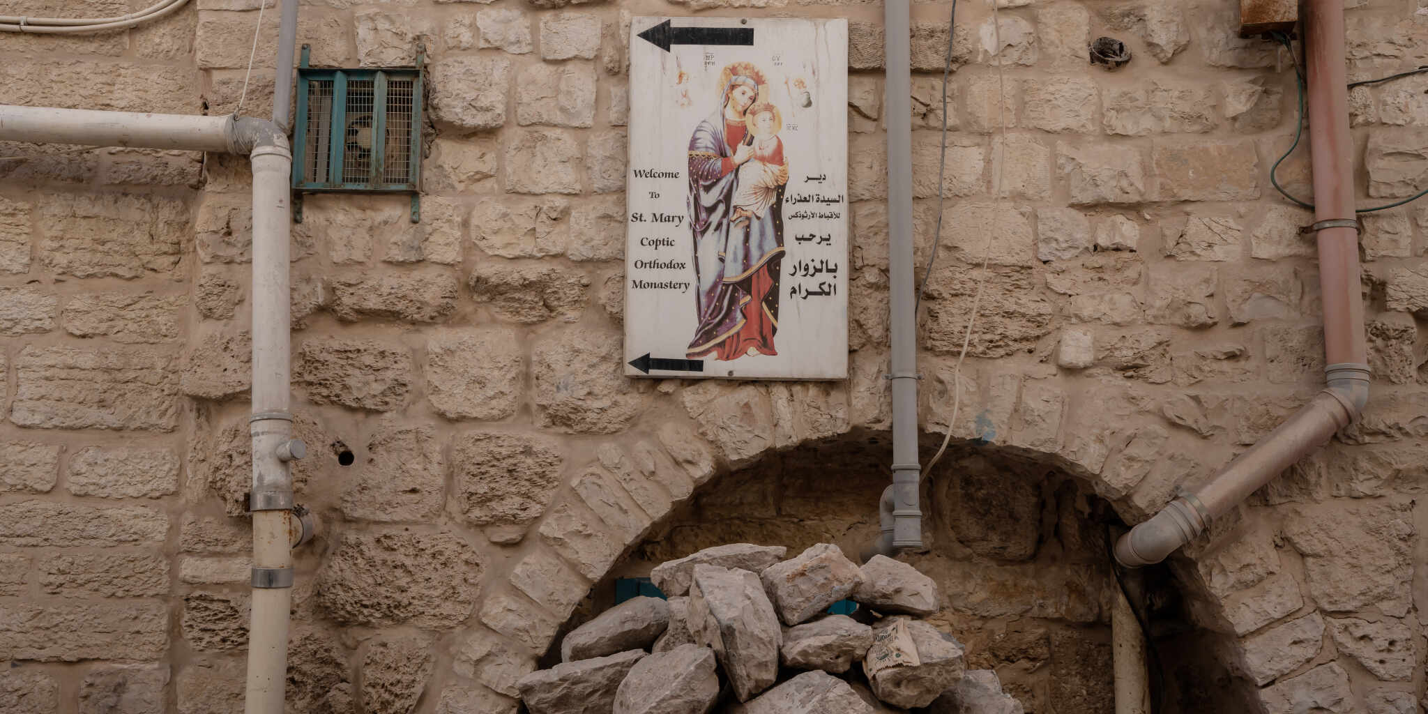 Une affiche indique une église orthodoxe copte au desus d'un tas de gravats, dans une rue vide de à Bethléem, Cisjordanie, le 22 décembre 2023. ADRIENNE SURPRENANT / MYOP POUR « LE MONDE »